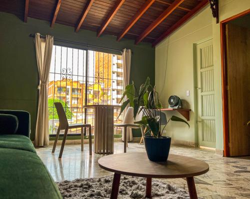a living room with a couch and a table with a plant at Tranquil Master Suite, Your Private Escape in Medellín