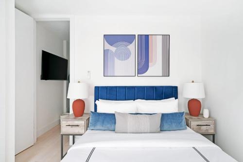 a bedroom with a blue and white bed with two tables at 48-3RW Brand New 1BR Prime Hells Kitchen - W D in New York