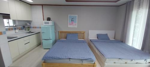 eine kleine Küche mit 2 Betten in einem Zimmer in der Unterkunft Toursketch Pension in Seogwipo