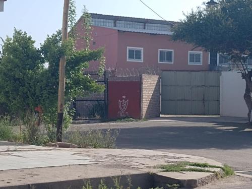 a house with a red fence and a driveway at Tulymary in Ciudad Lujan de Cuyo