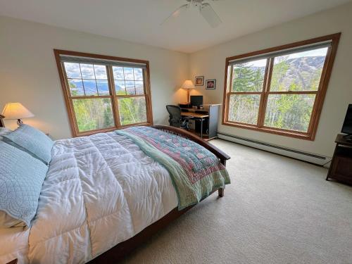 ein Schlafzimmer mit einem Bett und zwei großen Fenstern in der Unterkunft SH3 Luxurious Stonehill Townhouse in Bretton Woods with Magnificent View in Bretton Woods