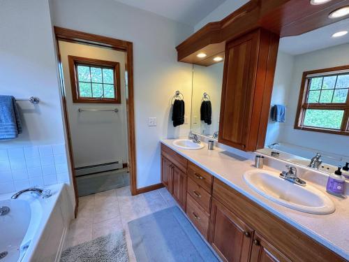 ein Badezimmer mit zwei Waschbecken und einer Badewanne in der Unterkunft SH3 Luxurious Stonehill Townhouse in Bretton Woods with Magnificent View in Bretton Woods