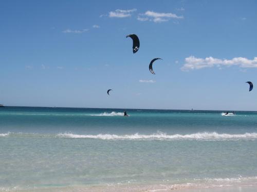 a group of people kite surfing in the ocean at Hotel Onda Marina in San Teodoro