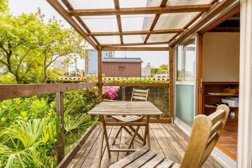 a wooden deck with a wooden table and chairs at アブラサカスペース in Nara