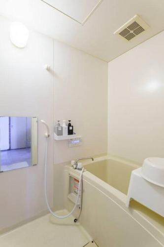 a bathroom with a shower and a tub and a sink at アブラサカスペース in Nara