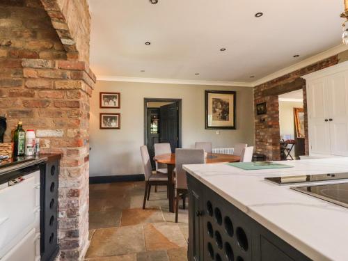 a kitchen and dining room with a brick wall at Moor End Manor in Poulton le Fylde