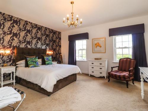 1 dormitorio con 1 cama y 1 silla en Moor End Manor, en Poulton le Fylde