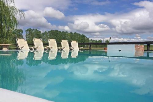 un grupo de sillas sentadas junto a una piscina en Gran casa de campo en el Valle de Uco con espectaculares vistas DOLAR BLUE en Tunuyán