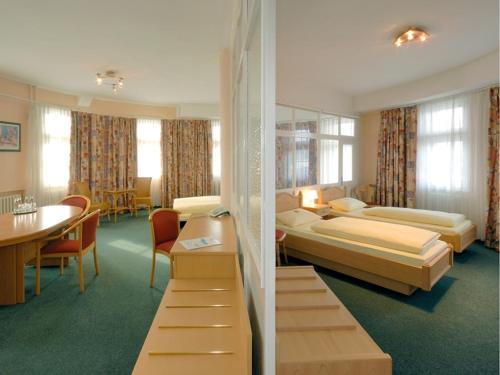 ein Hotelzimmer mit 2 Betten und einem Tisch in der Unterkunft Hotel und Rasthof AVUS in Berlin