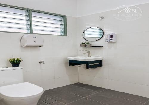 a bathroom with a toilet and a sink and a mirror at PD 14Pax 4BR Double Storey House Lukut in Port Dickson