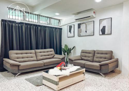 a living room with two couches and a table at PD 14Pax 4BR Double Storey House Lukut in Port Dickson