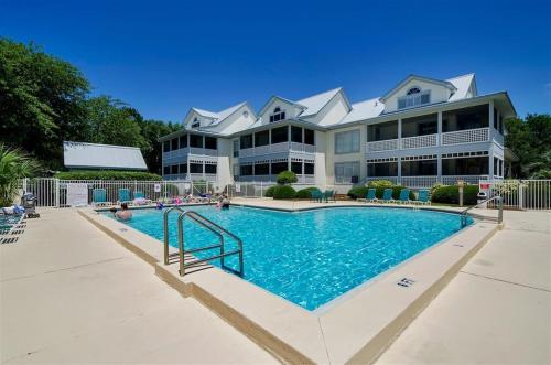 un grand immeuble avec une grande piscine dans l'établissement Gated Gulf Front Condo in Hidden Dunes Beach & Tennis Resort, à Destin