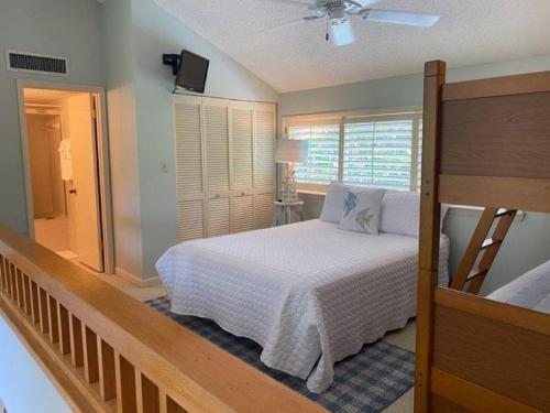 a bedroom with a white bed and a window at Gated Gulf Front Condo in Hidden Dunes Beach & Tennis Resort in Destin