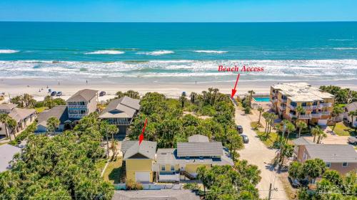 una vista aérea de la playa con un edificio con un cartel que lee nombres de ladrillo en Lovely Guesthouse Loft with Balcony and Hammock STEPS from the Beach! en New Smyrna Beach