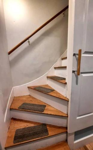 a staircase with wooden floors and a white door at Guest suite in historical district in Gloucester