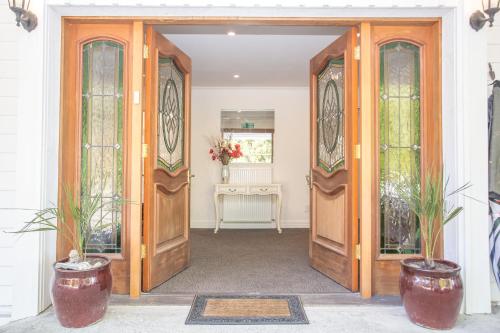 an open door into a room with two potted plants at Westholm Lodge in Harihari