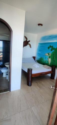 a room with a bed with a painting on the wall at Morro Beach Hotel in Morro de São Paulo