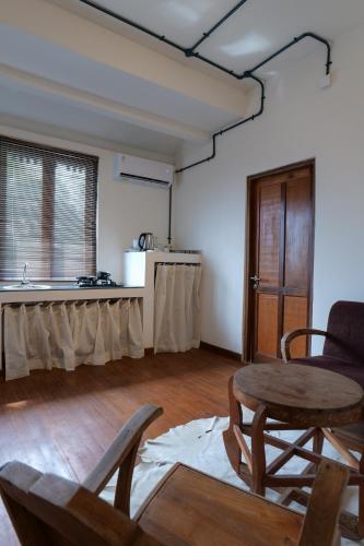 a living room with a table and a kitchen at Kresna By The Sea By Kresna Hospitality in Seminyak