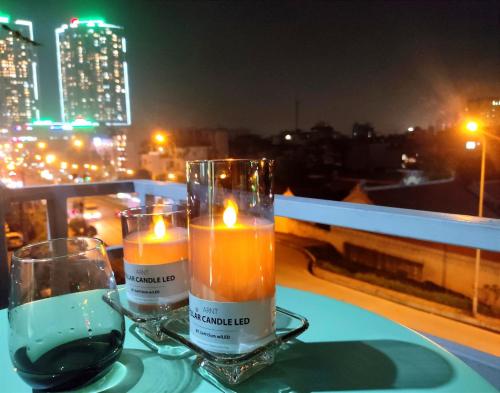 two candles on a table with a view of a city at Homestay Casa 69 in Hanoi