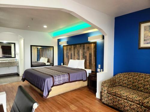 Habitación de hotel con cama y sofá en Express Inn Tomball en Tomball