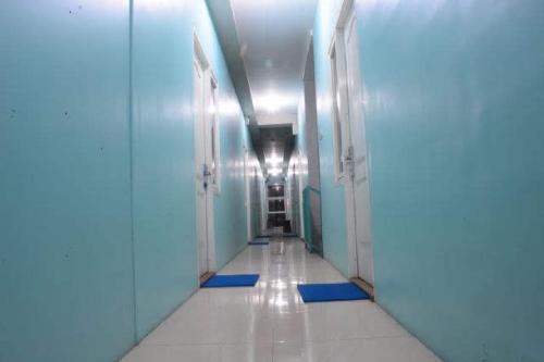 Mojokerto的住宿－MOJOKERTO GUESTHOUSE，医院走廊的走廊,有蓝色和白色的墙壁