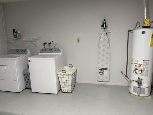 a laundry room with two machines and a refrigerator at Family-Friendly DIsney Getaway in Kissimmee