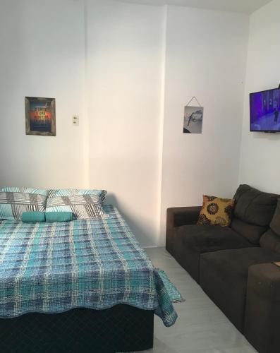 salon z łóżkiem i kanapą w obiekcie Kitnet Costa faria w mieście Porto Alegre
