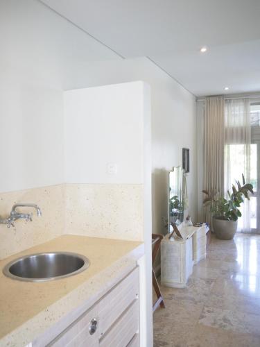 a kitchen with a sink and a counter top at Kresna By The Sea By Kresna Hospitality in Seminyak