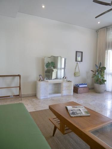 a living room with a coffee table and a mirror at Kresna By The Sea By Kresna Hospitality in Seminyak