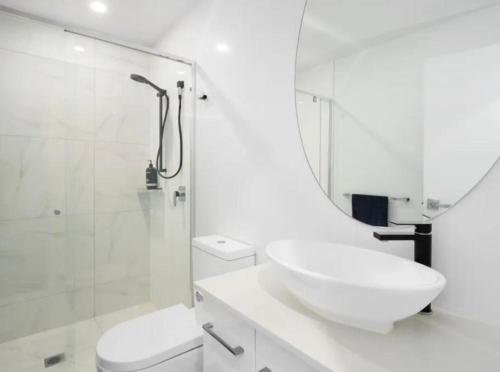 uma casa de banho branca com um lavatório e um chuveiro em Luxury Private Queen Room with Balcony & Bathroom in Shared Apartment Panorama Gold Coast em Gold Coast