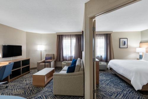 a hotel room with a bed and a tv at Candlewood Suites Chesapeake-Suffolk by IHG in Chesapeake
