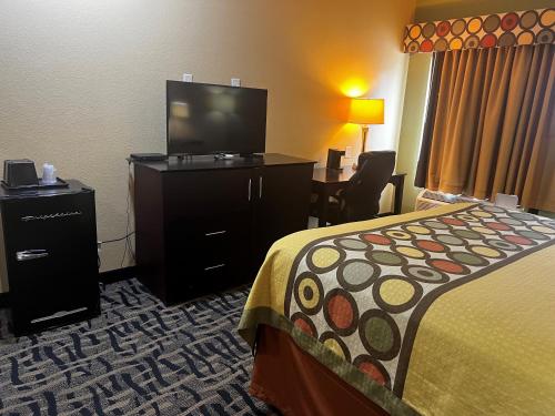 a hotel room with a bed and a flat screen tv at Super 8 by Wyndham Pasadena in Pasadena