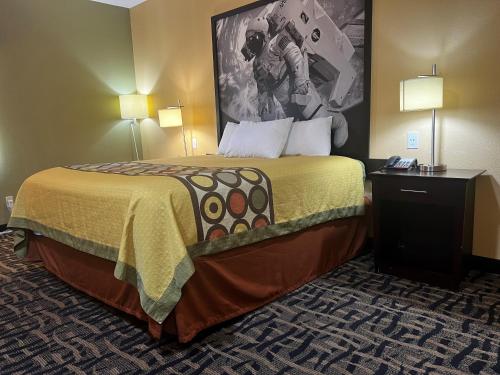 a large bed in a hotel room with two lamps at Super 8 by Wyndham Pasadena in Pasadena