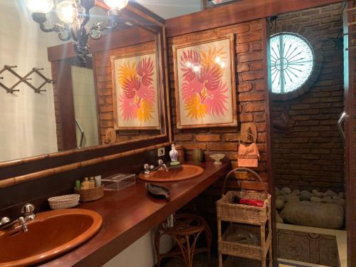 uma casa de banho com 2 lavatórios e um espelho em Casa com cachoeira e rio particular em Petrópolis