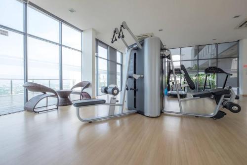 a gym with cardio equipment in a large room with windows at Studio Diane in Permatang Pauh