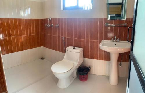 a bathroom with a toilet and a sink at The North Face Inn in Pokhara