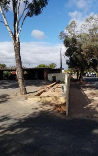 a parking lot with a tree and a building at Tranquil Studio Apartment Just 3km from Port Pirie in Port Pirie