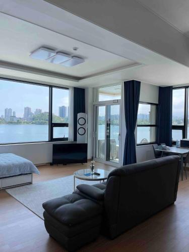 a living room with a couch and a large window at Lakestone&Hotel Sokcho in Sokcho