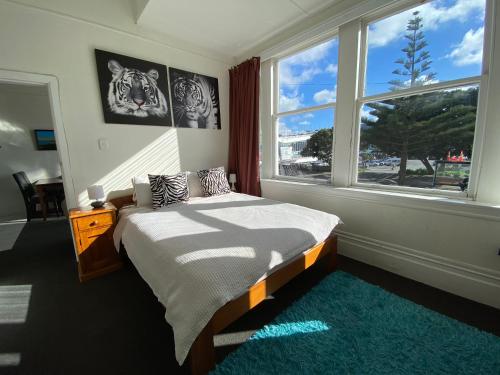 a bedroom with a bed and a large window at Beach house in Oriental Parade in Wellington