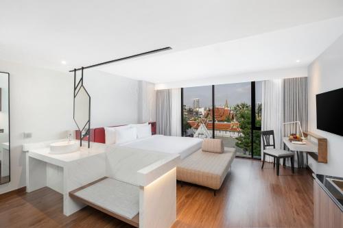 a white bedroom with a large white bed and a desk at Centara Life Hotel Bangkok Phra Nakhon in Bangkok