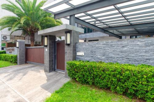 a house with a fence and a gate and bushes at Relax BnB in Dongshan