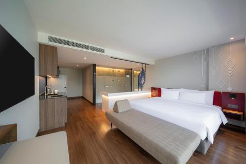 a hotel room with a large bed and a couch at Centara Life Hotel Bangkok Phra Nakhon in Bangkok