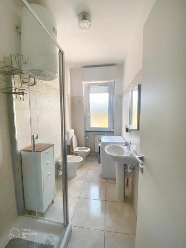 Baño blanco con aseo y lavamanos en Casa Conti, en San Bartolomeo al Mare