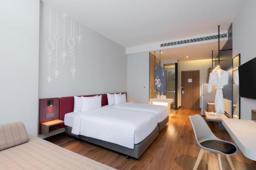 a bedroom with a large white bed and a dressing room at Centara Life Hotel Bangkok Phra Nakhon in Bangkok