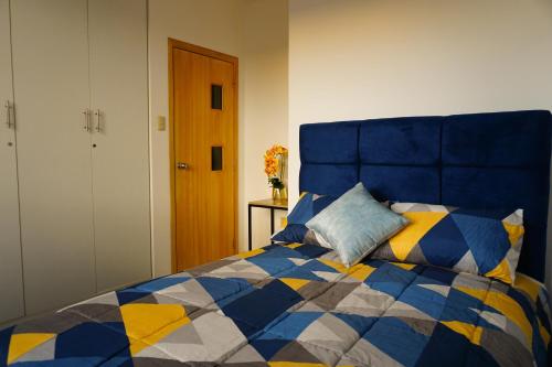 a blue and yellow bed with a blue and yellow at Casa Familiar con Piscina en Urbanización privada in Manta