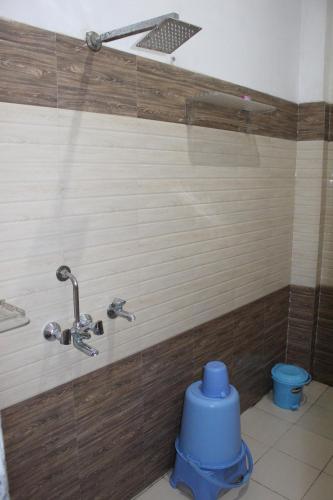 a bathroom with a shower with a blue toilet at AK Corbett Family Homestay in Rāmnagar