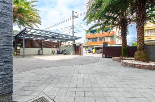 a parking lot with palm trees in front of a building at Relax BnB in Dongshan