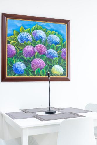 a painting of purple and blue flowers on a white table at Edificio Vida Nueva in Cali