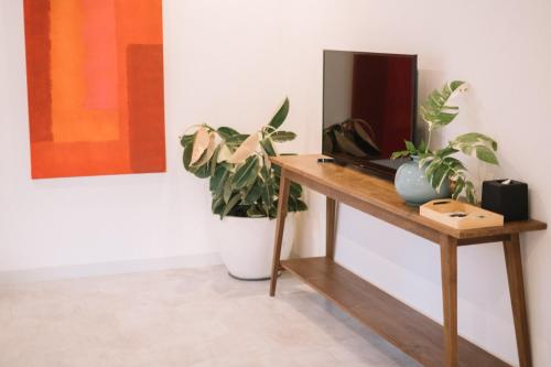 a desk with a television and a potted plant at Kresna By The Sea By Kresna Hospitality in Seminyak