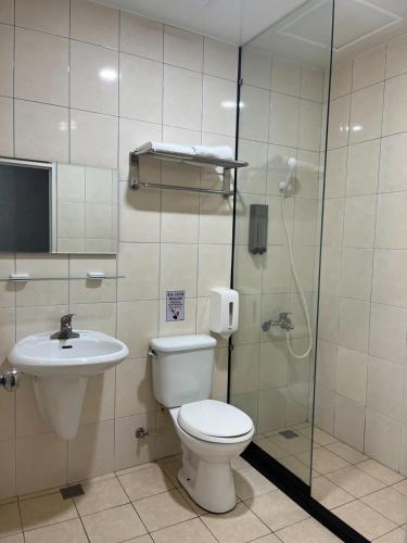 台南的住宿－鐵道大飯店，浴室配有卫生间、盥洗盆和淋浴。